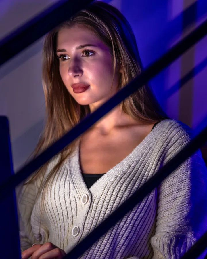 A student working on a laptop late in the evening